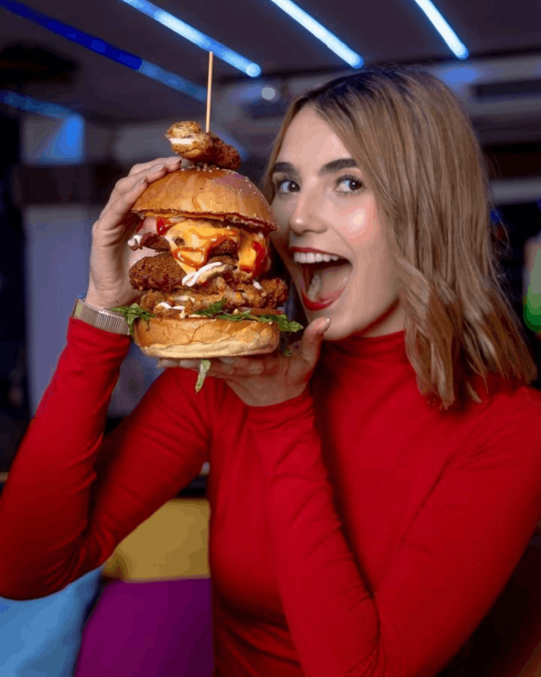 Clienta disfrutando una hamburguesa en el ambiente de En Alturas Café, Mérida.