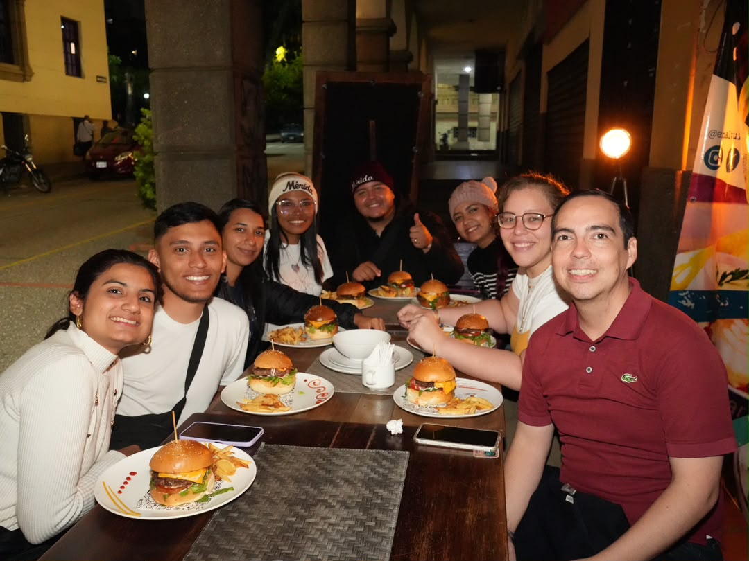 Turistas disfrutando hamburguesas y gastronomía en En Alturas Café Bistró Bar, Mérida.