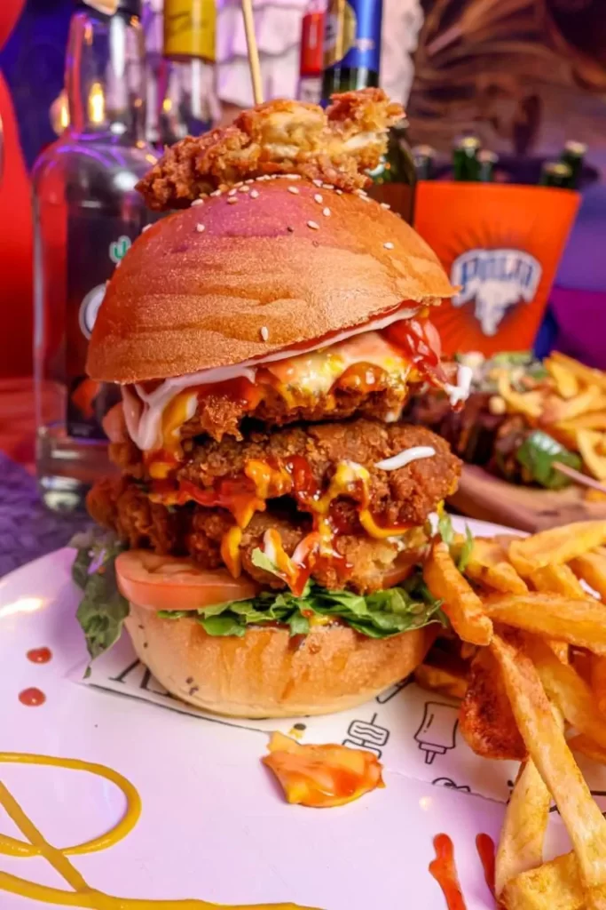 Hamburguesa crispy con papas fritas y bebidas en En Alturas Café, Mérida.