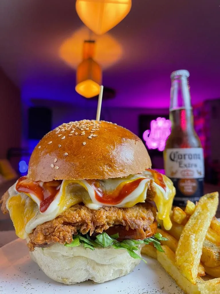 Hamburguesa de pollo crispy con lechuga y salsas en En Alturas Café Bistró Bar, Mérida.