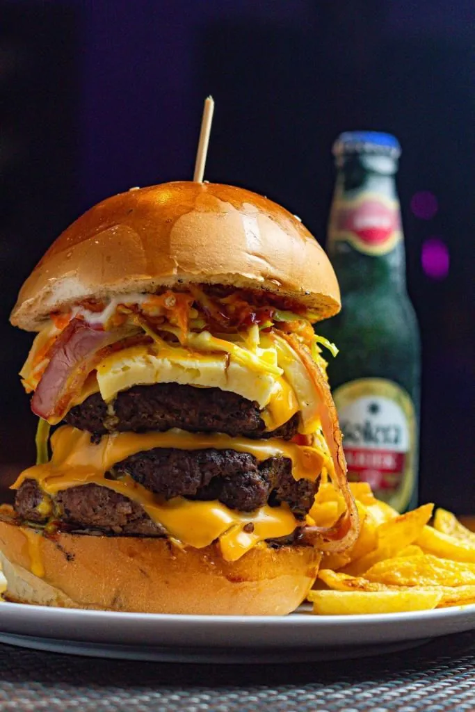 Hamburguesa triple carne con queso cheddar y papas fritas en En Alturas Café, Mérida.