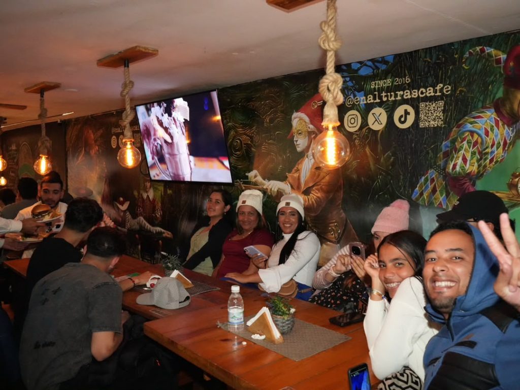 Grupo de turistas disfrutando gastronomía y música en vivo en En Alturas Café Bistró Bar durante la temporada vacacional 2026 en Mérida.